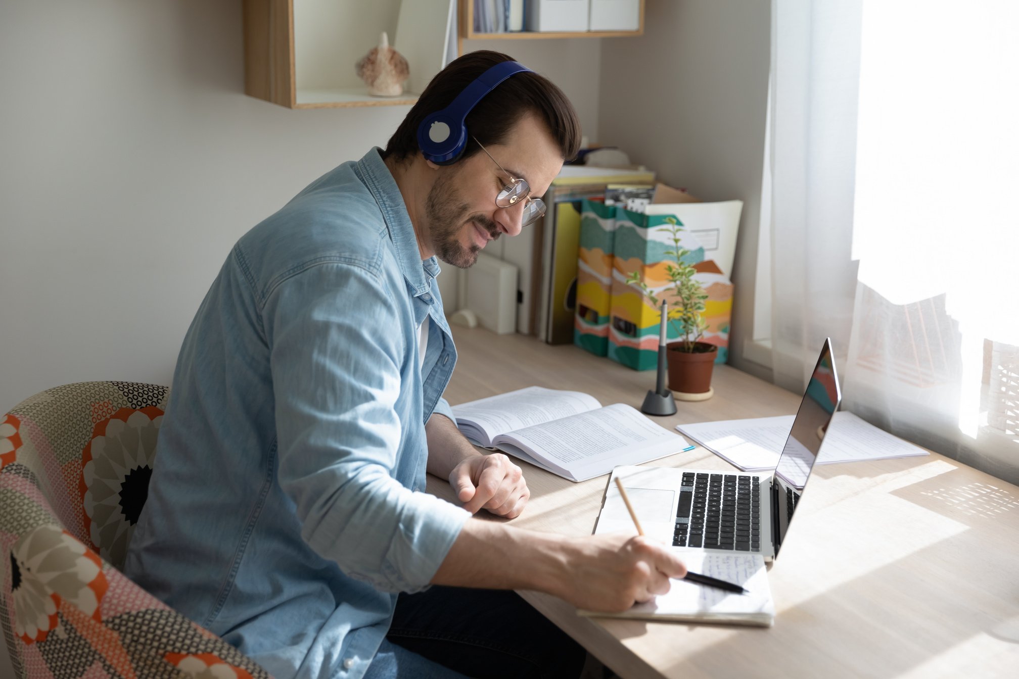 Happy young smart guy studying on online courses.